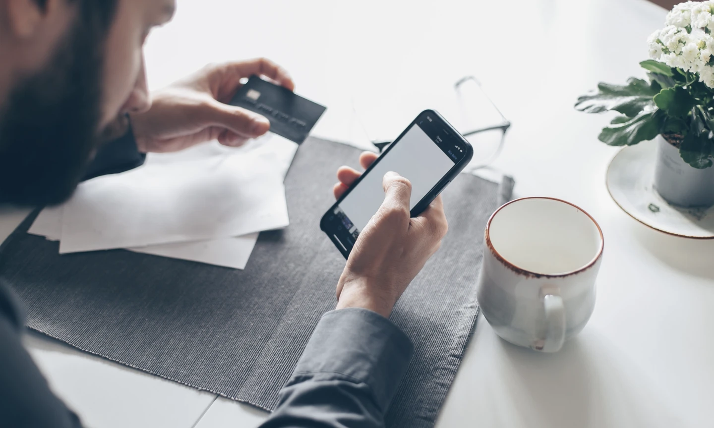 Immagine con uomo che usa app bancaria da mobile