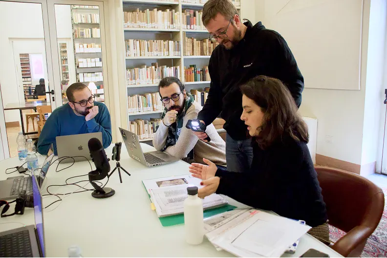 i ricercatori hedron osservano il lavoro dei filologi in biblioteca